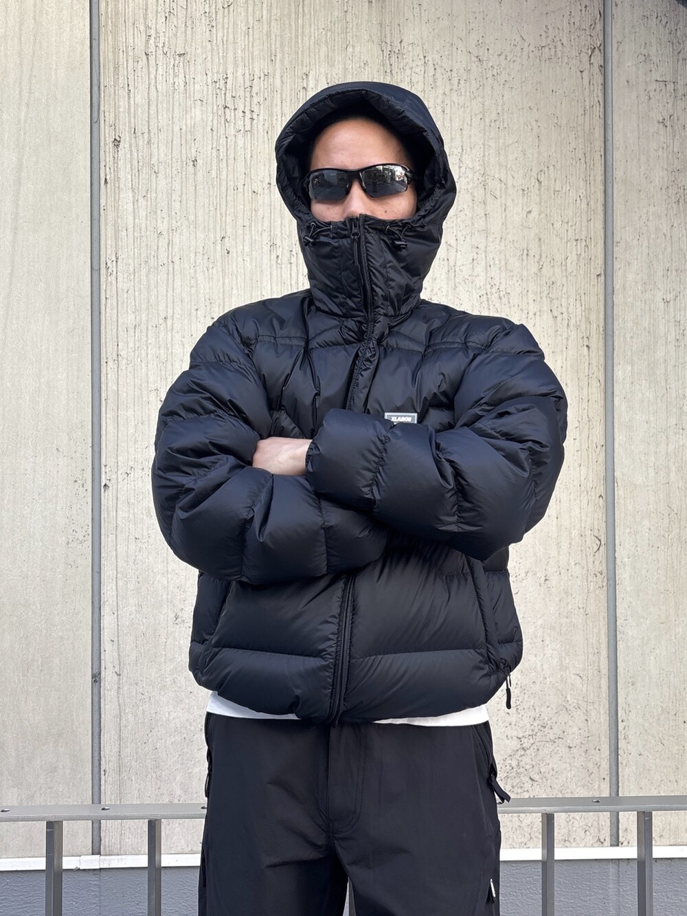 グリーン系のダウンジャケット/コート、ブラック系のその他パンツを着用したメンズの冬コーディネートの6枚目の写真