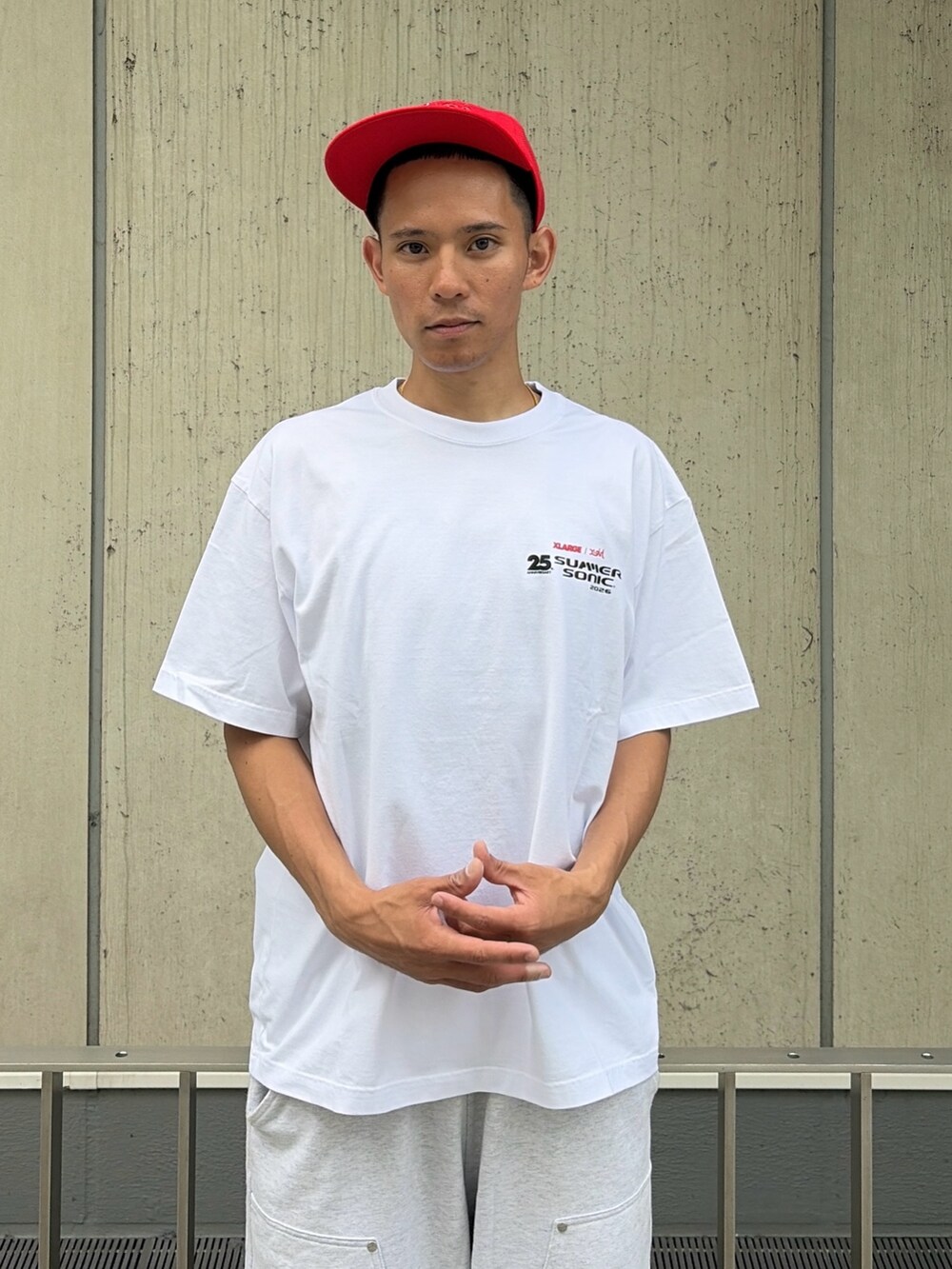 グレー系のスウェットパンツ、レッド系のキャップを着用したメンズの夏コーディネートの6枚目の写真