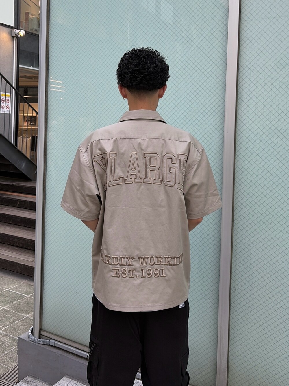 ブラック系のカーゴパンツ、グリーン系のシャツ/ブラウス、ホワイト系のTシャツ/カットソーを着用したメンズの春コーディネートの5枚目の写真