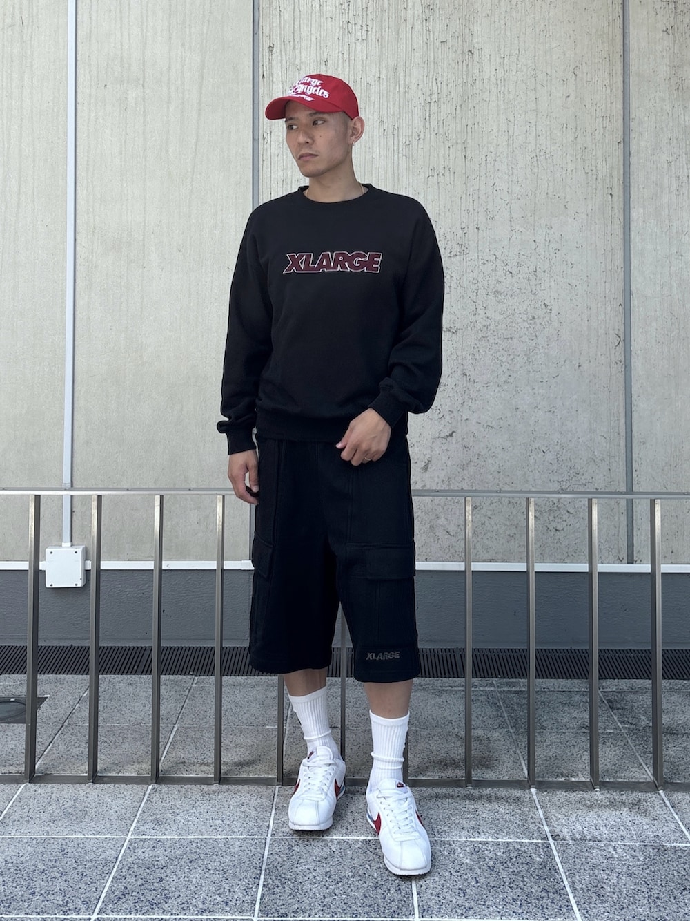 ブラック系のスウェット、ブラック系のスウェットパンツ、レッド系のキャップを着用したメンズの秋コーディネートの2枚目の写真