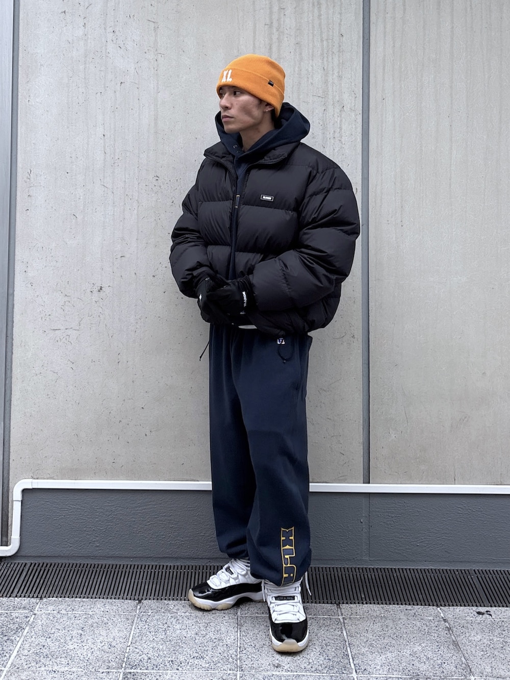 ブラック系のダウンジャケット/コート、ブルー系のパーカー、ブルー系のスウェットパンツを着用したメンズの秋コーディネートの2枚目の写真