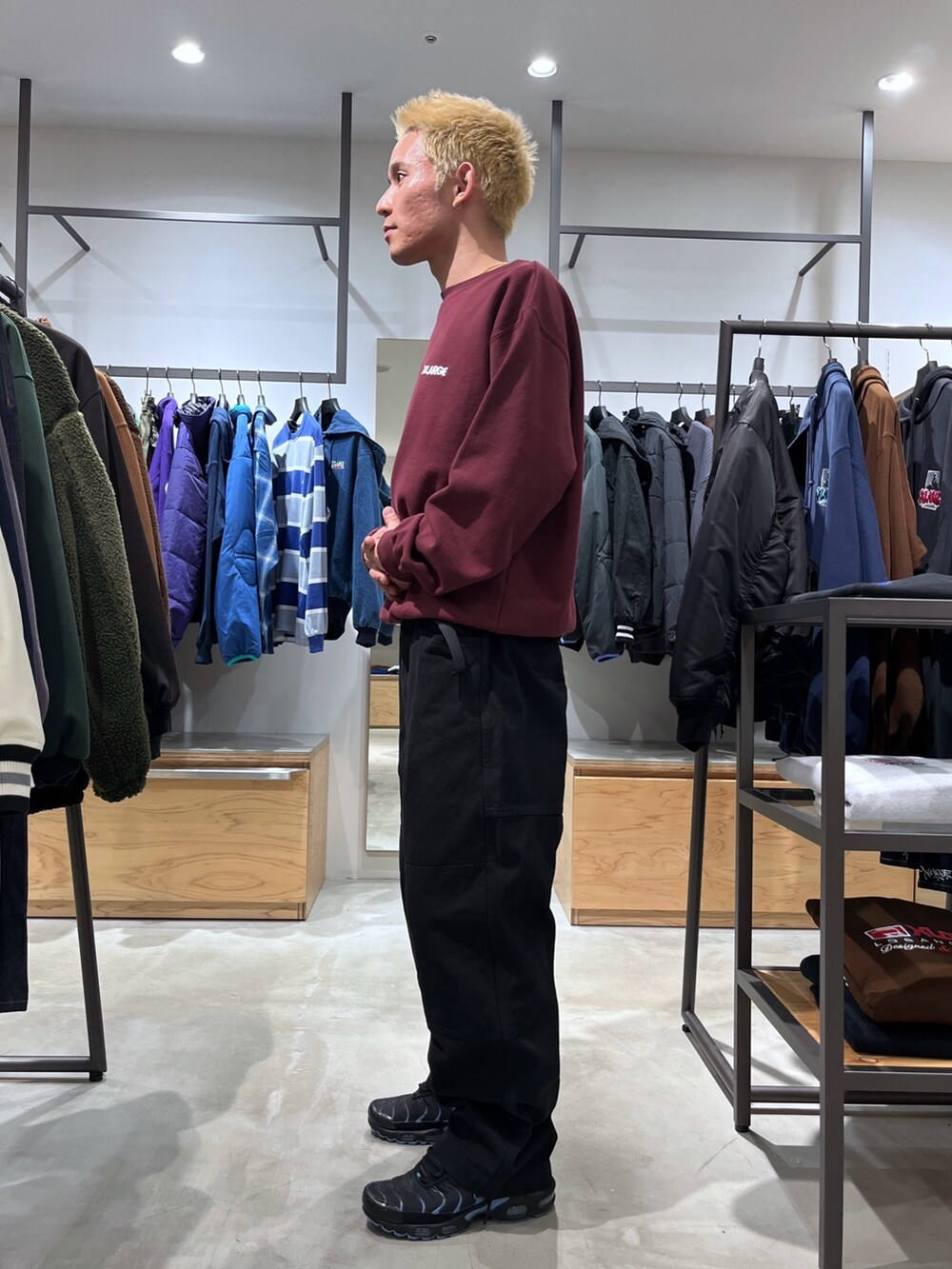 レッド系のスウェット、ブラック系のその他パンツ、ブラック系のダウンベストを着用したメンズの秋コーディネートの2枚目の写真