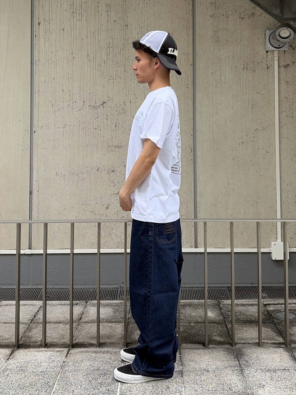 ブルー系のその他パンツ、ホワイト系のTシャツ/カットソー、ブラック系のキャップを着用したメンズの夏コーディネートの2枚目の写真