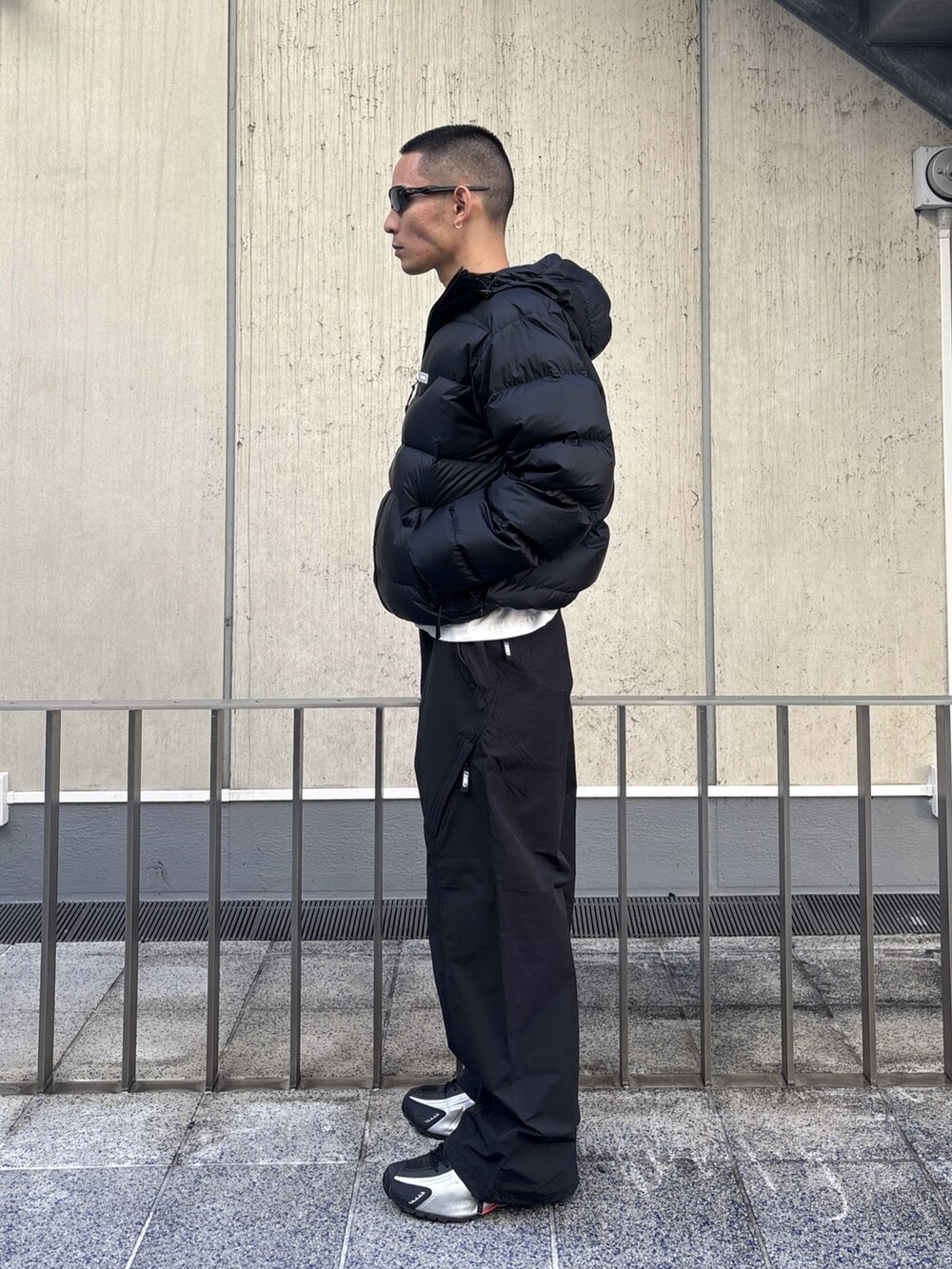 グリーン系のダウンジャケット/コート、ブラック系のその他パンツを着用したメンズの冬コーディネートの2枚目の写真