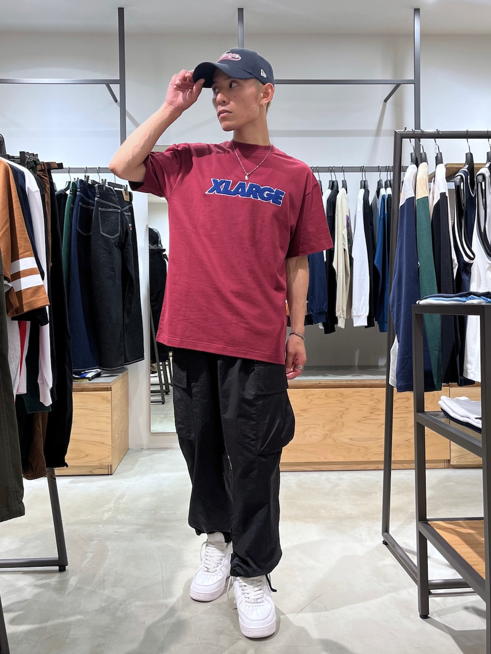 レッド系のTシャツ/カットソー、ブラック系のカーゴパンツ、ブルー系のキャップを着用したメンズの夏コーディネートの2枚目の写真