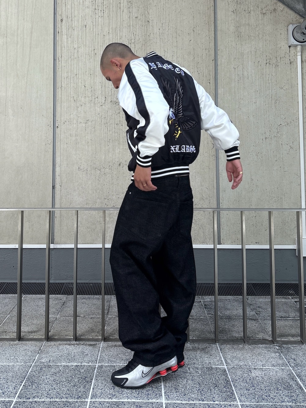 ブラック系のスカジャン、ブラック系のデニムパンツを着用したメンズの秋コーディネートの2枚目の写真