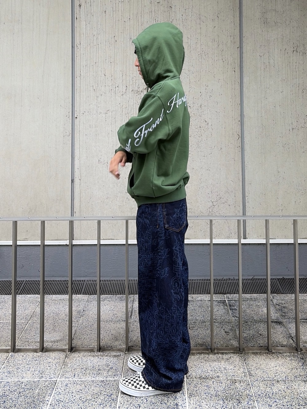 グリーン系のパーカー、ブルー系のデニムパンツ、レッド系のニットキャップ/ビーニーを着用したメンズの秋コーディネートの3枚目の写真