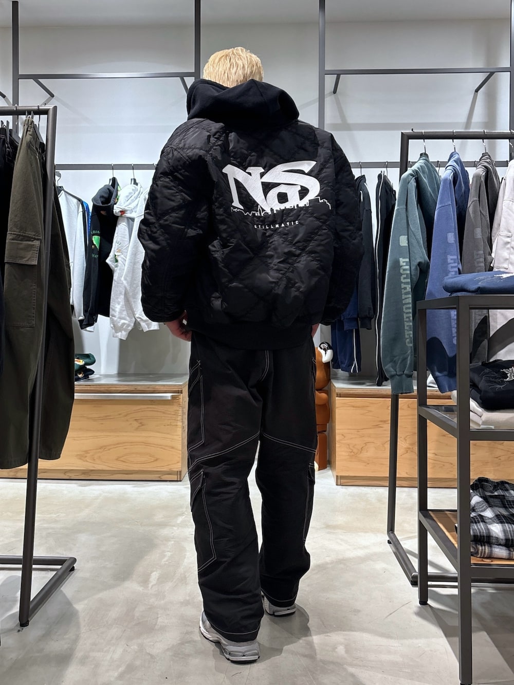 ブラック系のカーゴパンツ、ブラック系のブルゾン、ブラック系のパーカーを着用したメンズの冬コーディネートの6枚目の写真