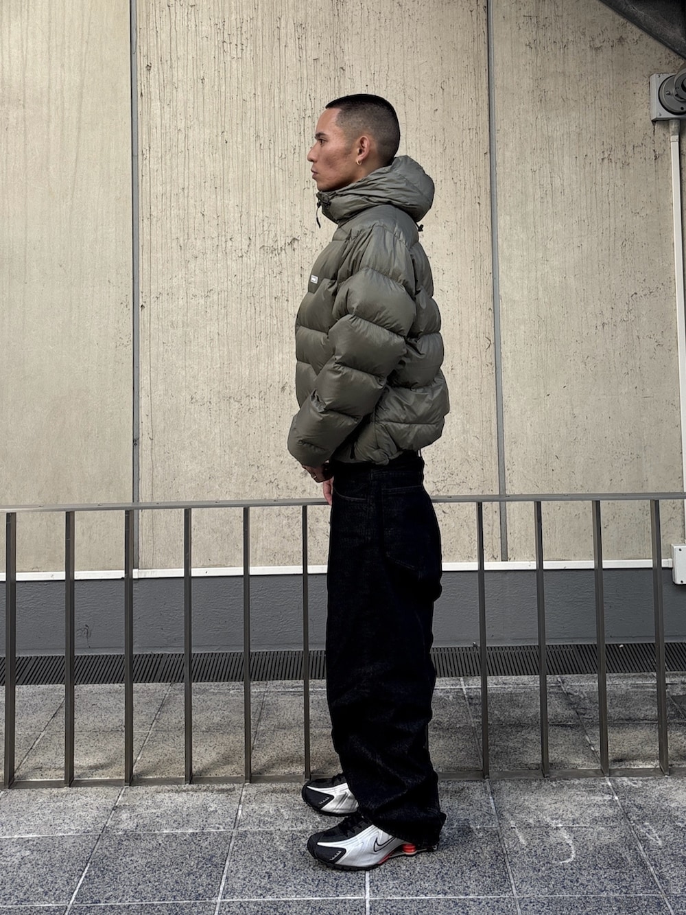 グリーン系のダウンジャケット/コート、ブラック系のデニムパンツを着用したメンズの秋コーディネートの2枚目の写真