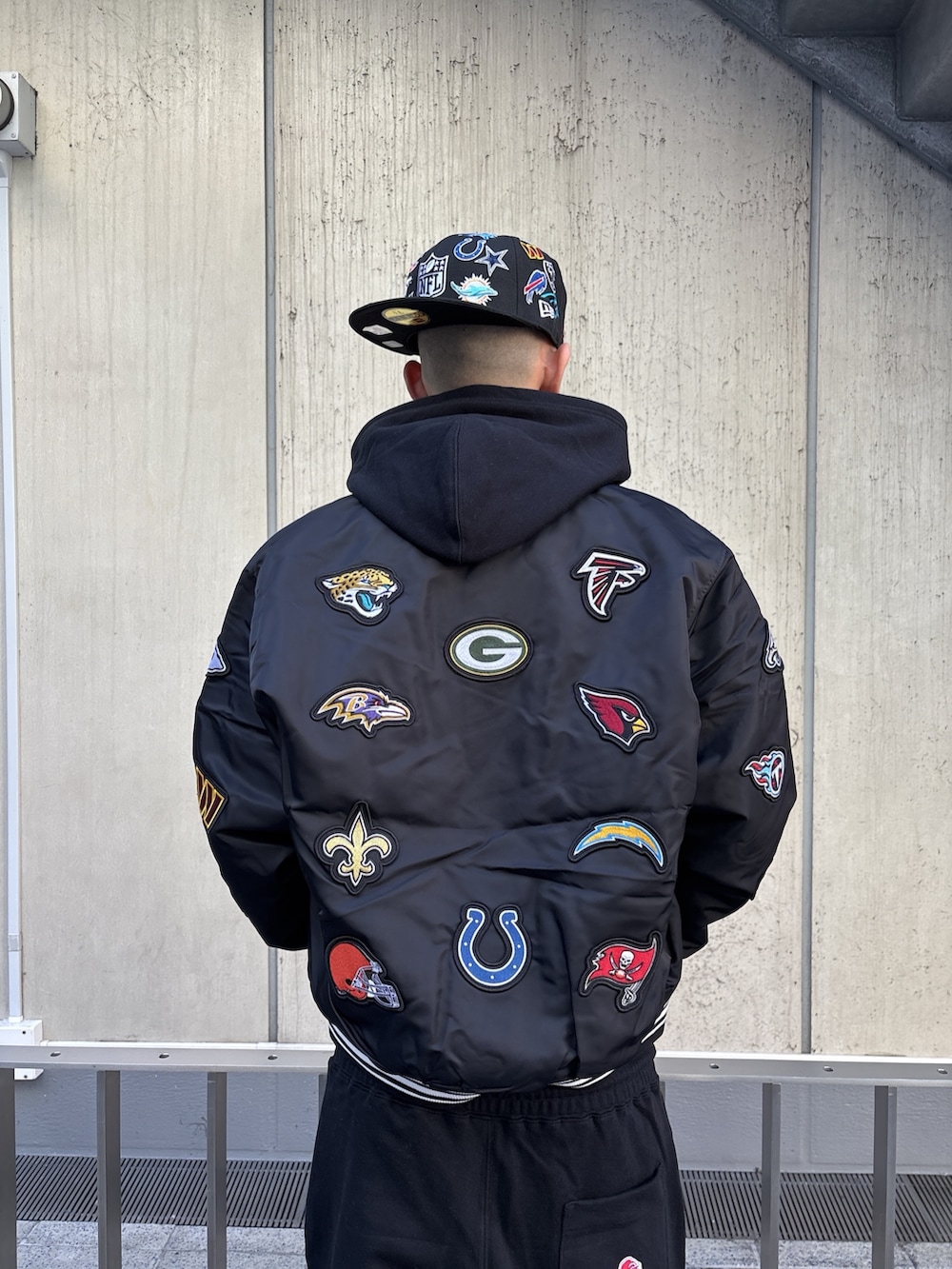 ブラック系のブルゾン、ブラック系のパーカー、ブラック系のスウェットパンツを着用したメンズの冬コーディネートの6枚目の写真