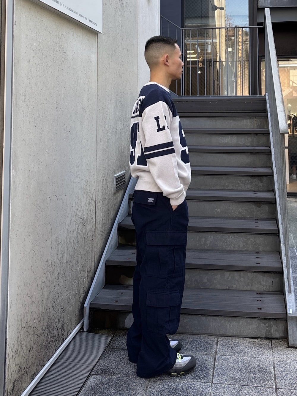 オレンジ系のニット/セーター、ブルー系のカーゴパンツを着用したメンズの冬コーディネートの4枚目の写真