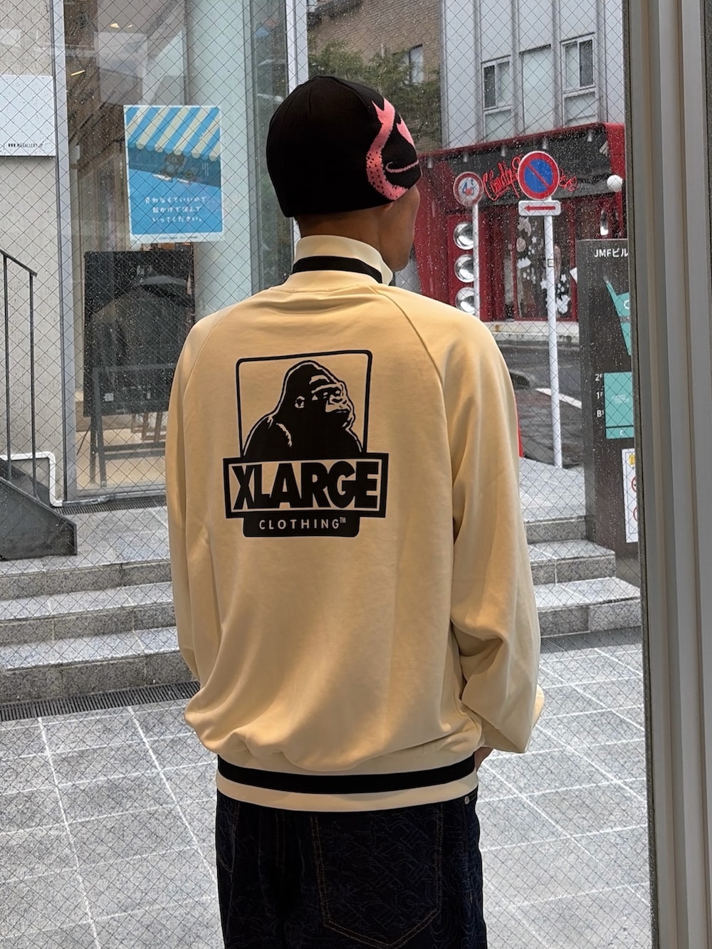ホワイト系のブルゾン、ブルー系のデニムパンツ、ブルー系のキャップを着用したメンズの秋コーディネートの6枚目の写真