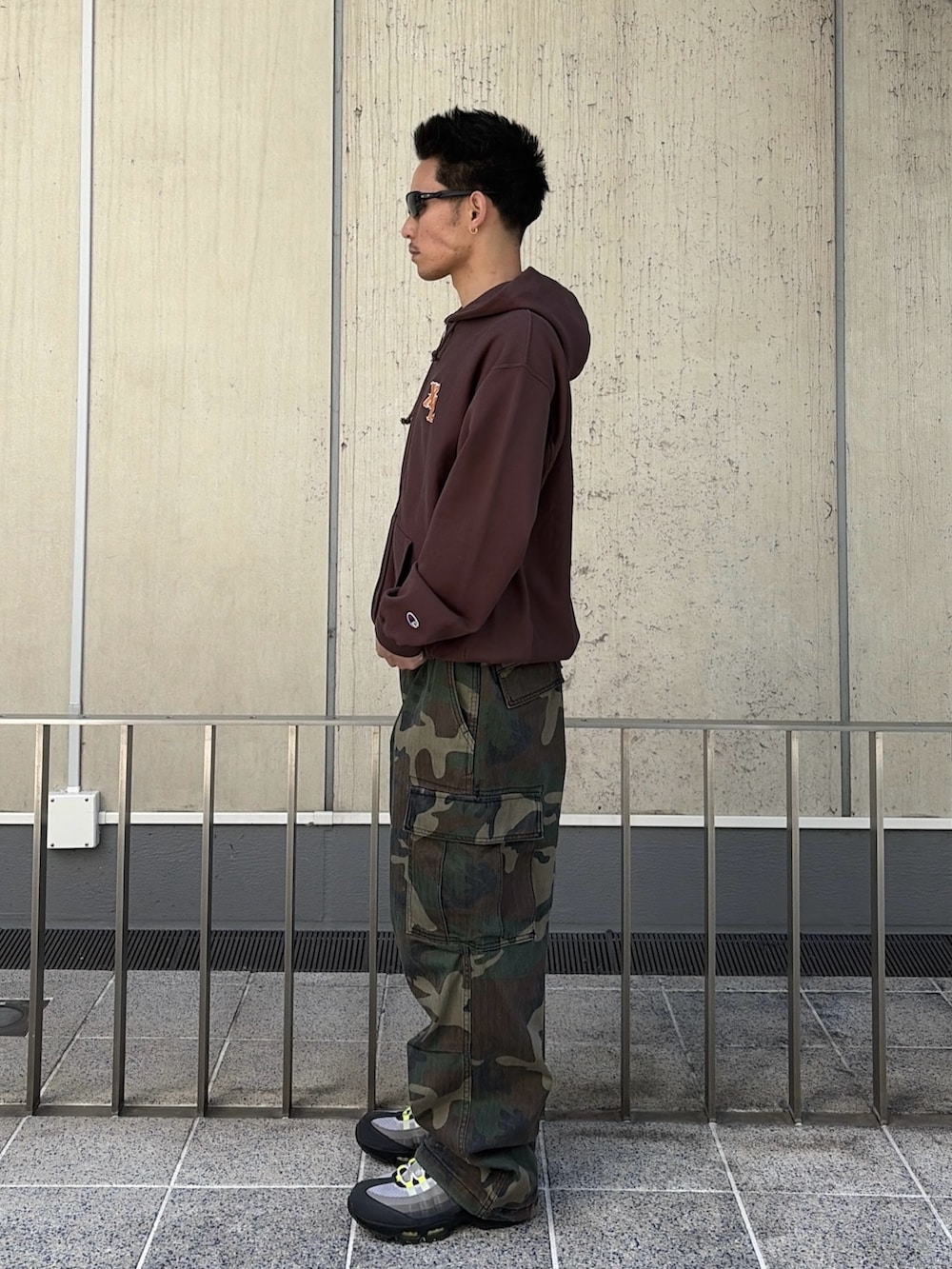 ブラウン系のパーカー、グリーン系のカーゴパンツを着用したメンズの春コーディネートの2枚目の写真