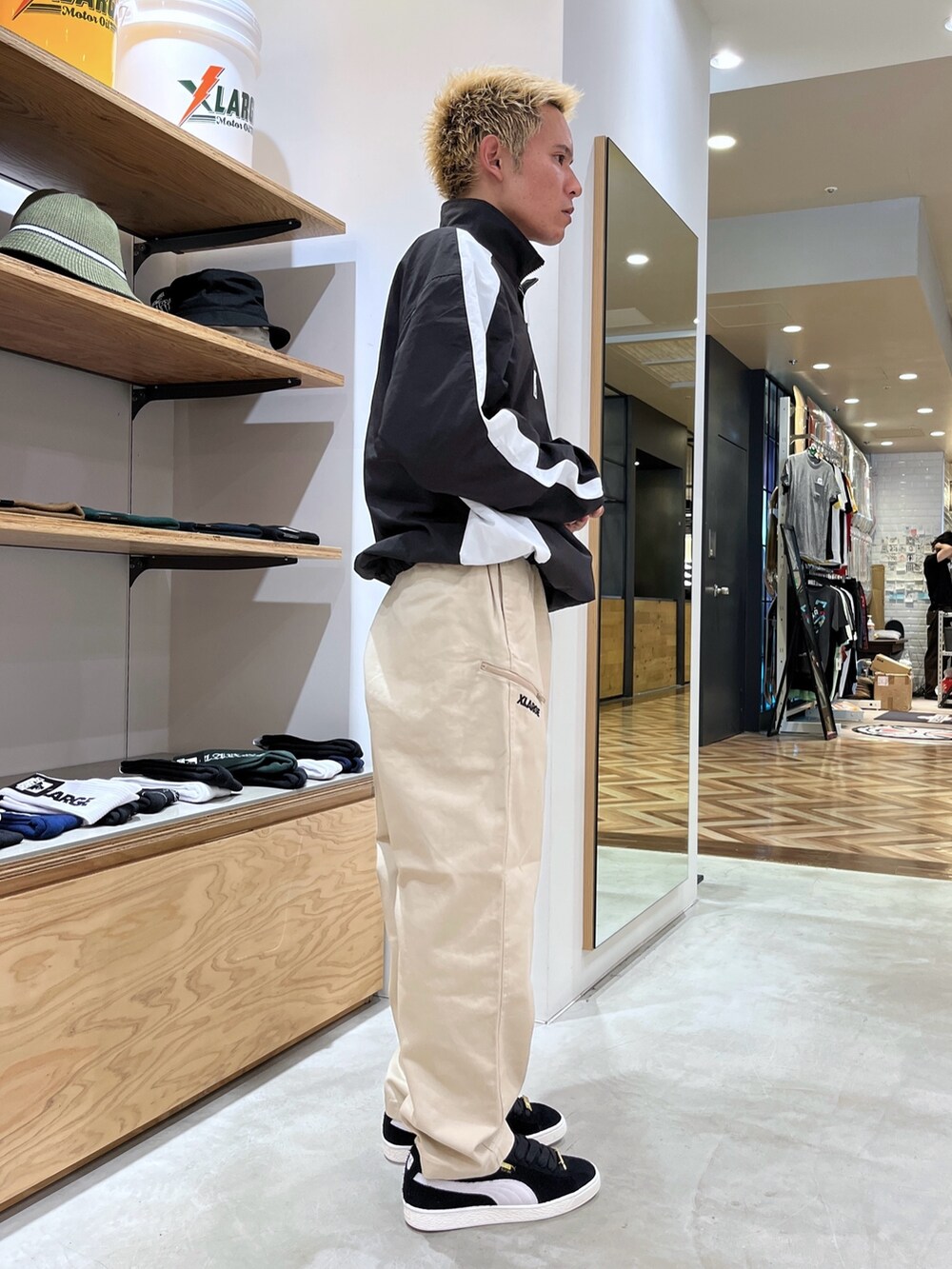 ブラック系のブルゾン、ベージュ系のその他パンツ、ブラック系のスニーカーを着用したメンズの秋コーディネートの3枚目の写真