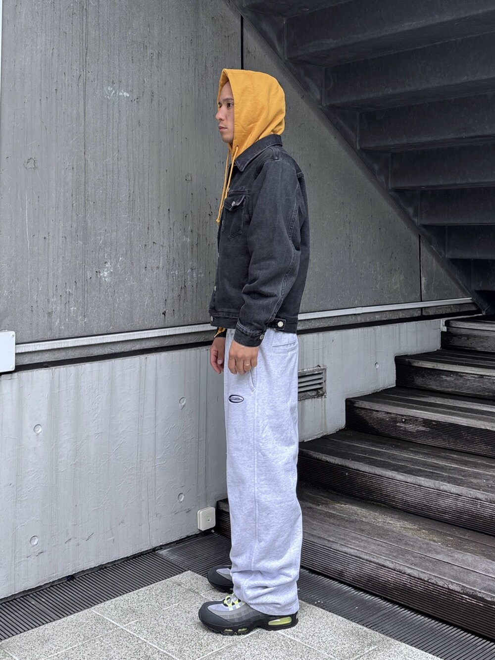 ブラック系のデニムジャケット、グレー系のスウェットパンツ、グレー系のパーカーを着用したメンズの秋コーディネートの3枚目の写真