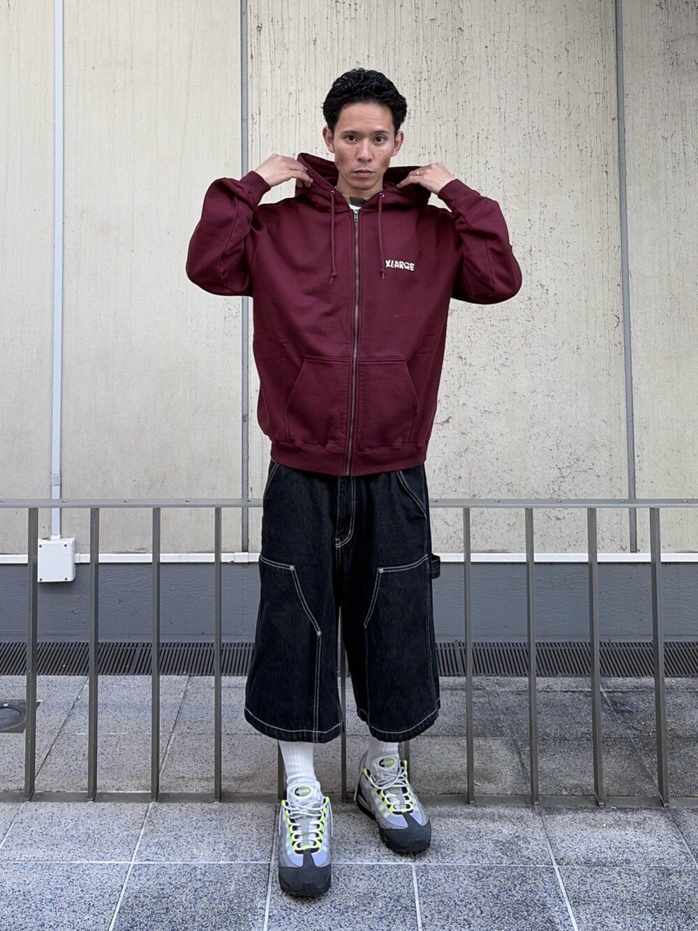 レッド系のパーカー、ブラック系のデニムパンツを着用したメンズの秋コーディネートの10枚目の写真