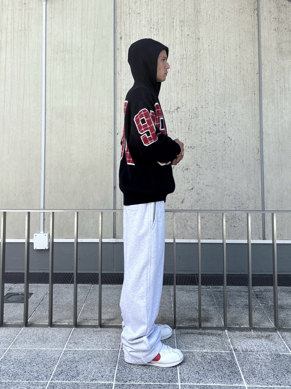 ブラック系のニット/セーター、グレー系のスウェットパンツを着用したメンズの秋コーディネートの3枚目の写真