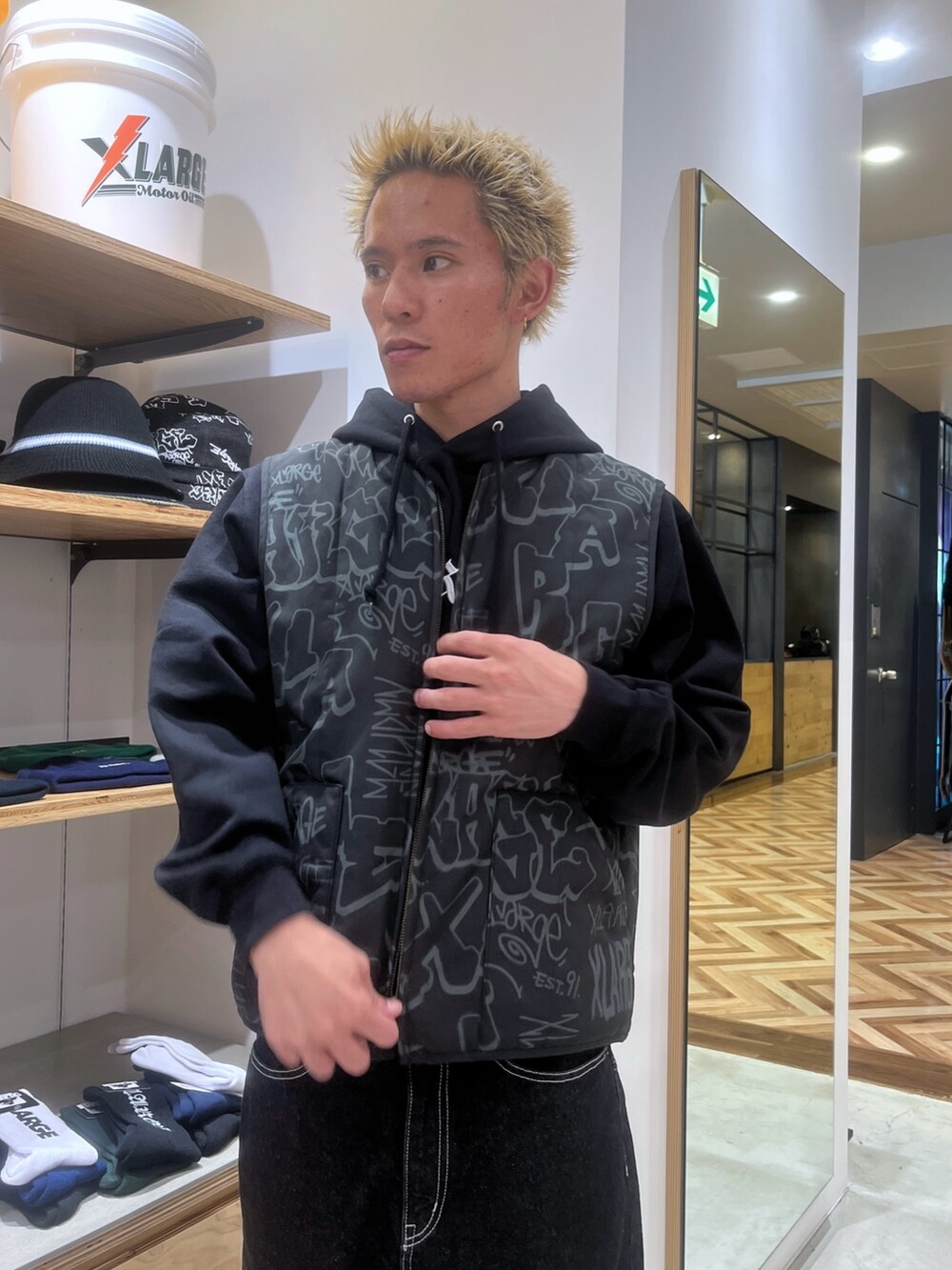 ブラック系のベスト、ブラック系のパーカー、ブラック系のデニムパンツを着用したメンズの秋コーディネートの6枚目の写真