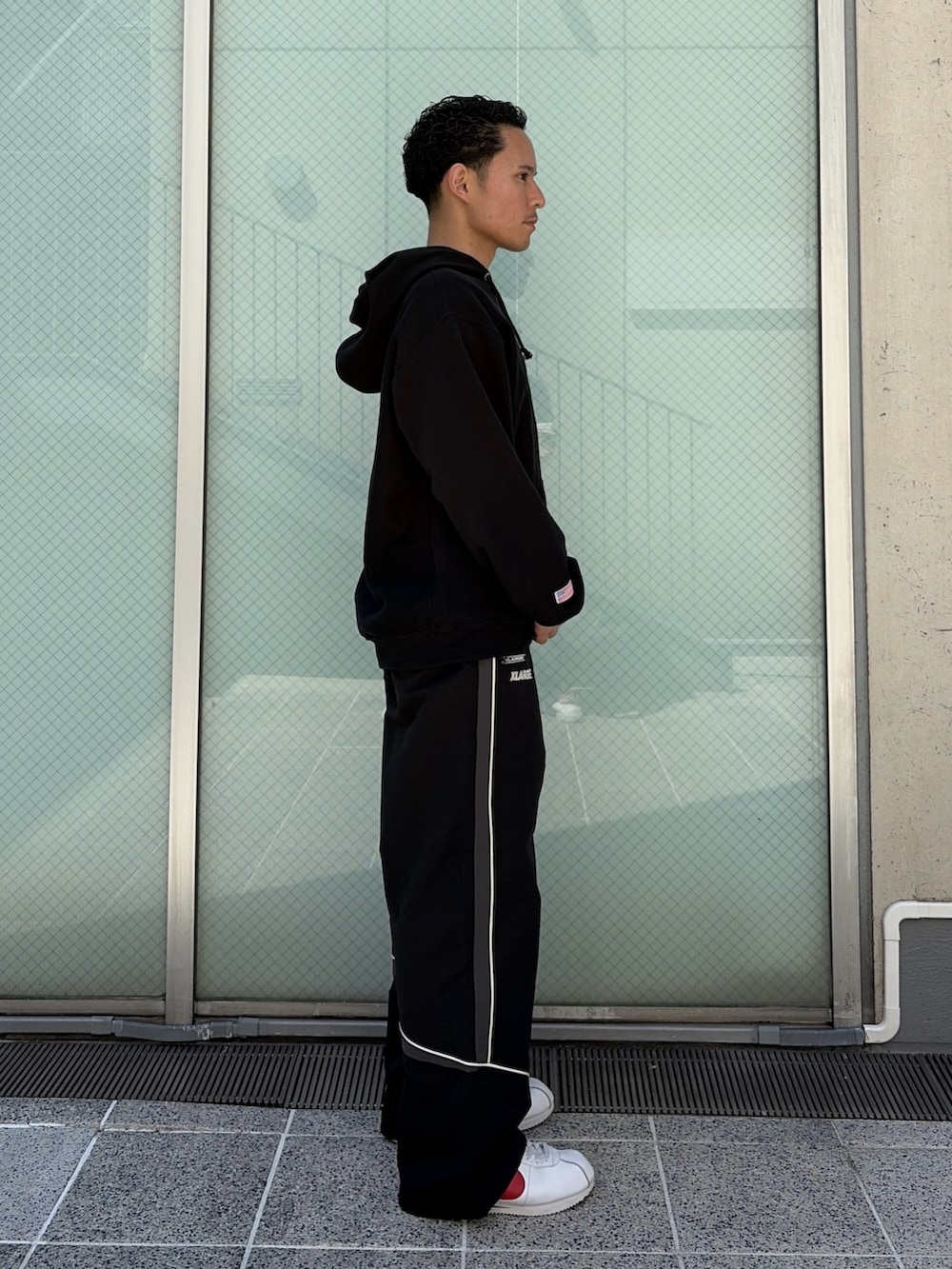 ブラウン系のパーカー、ブラック系のその他パンツを着用したメンズの春コーディネートの3枚目の写真