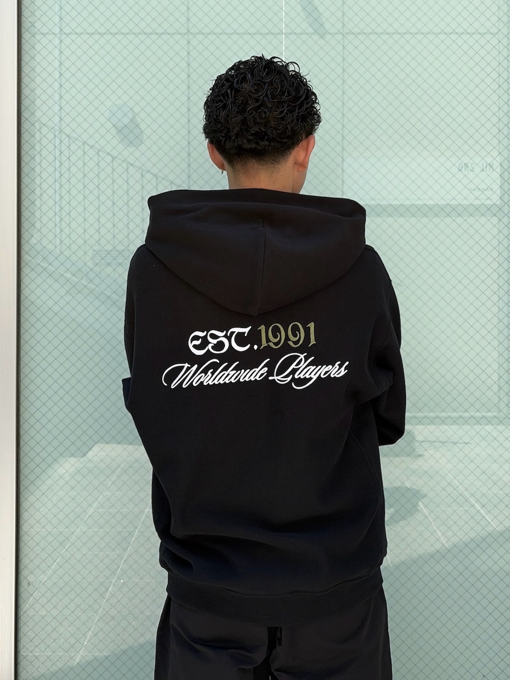 ブラウン系のパーカー、ブラック系のその他パンツを着用したメンズの春コーディネートの7枚目の写真