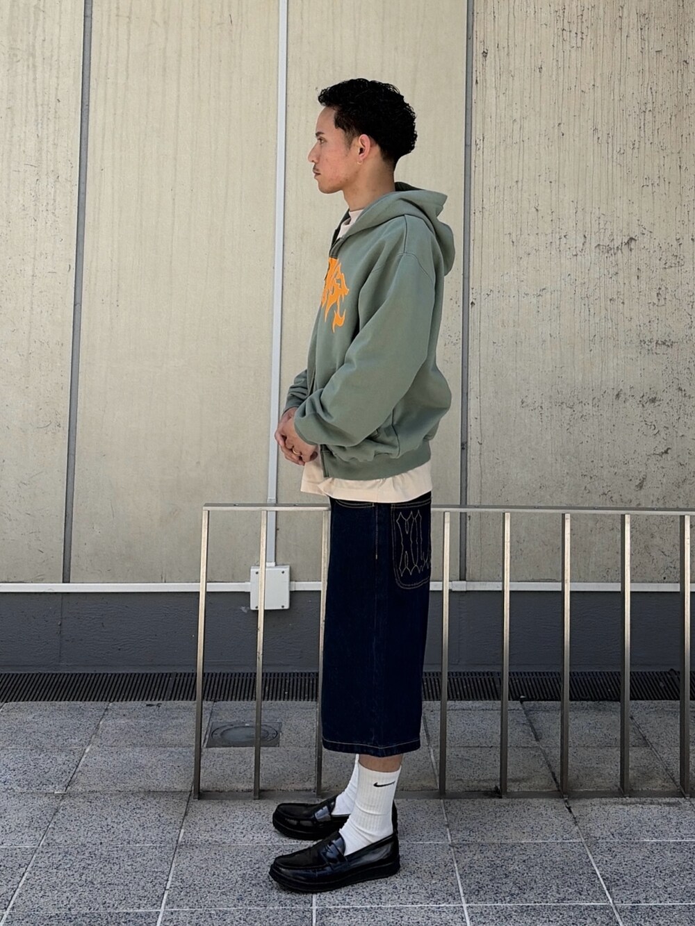 ピンク系のパーカー、ブルー系のデニムパンツを着用したメンズの春コーディネートの3枚目の写真