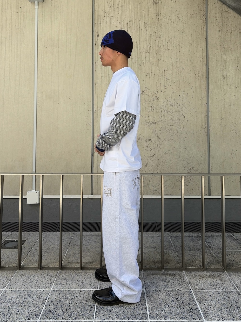 ホワイト系のTシャツ/カットソー、ブルー系のTシャツ/カットソー、グレー系のスウェットパンツを着用したメンズの春コーディネートの2枚目の写真