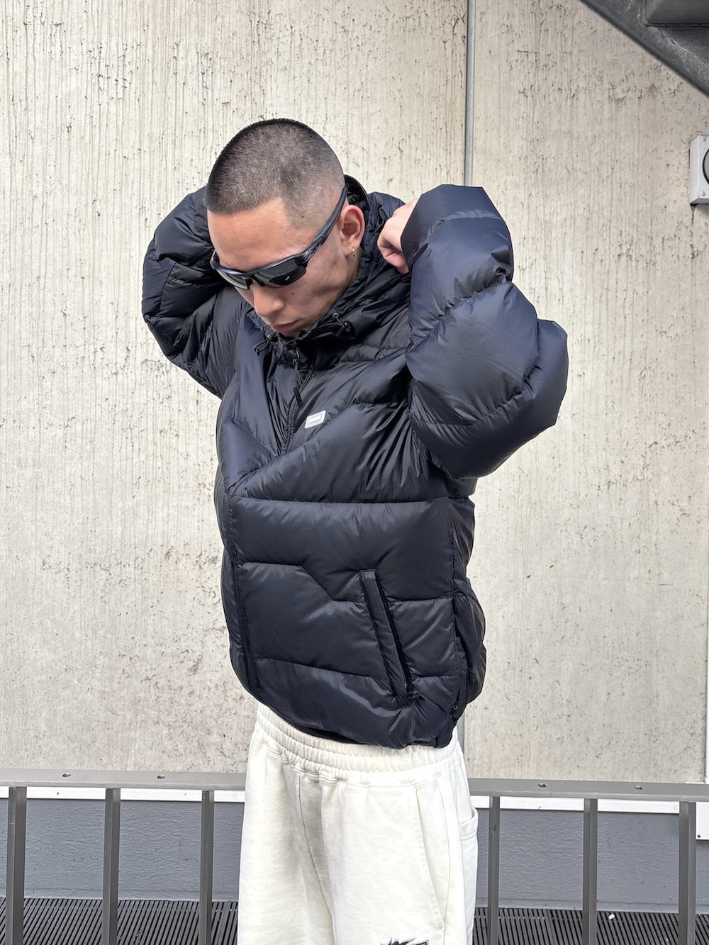 ブラウン系のダウンジャケット/コート、ホワイト系のスウェットパンツを着用したメンズの秋コーディネートの6枚目の写真