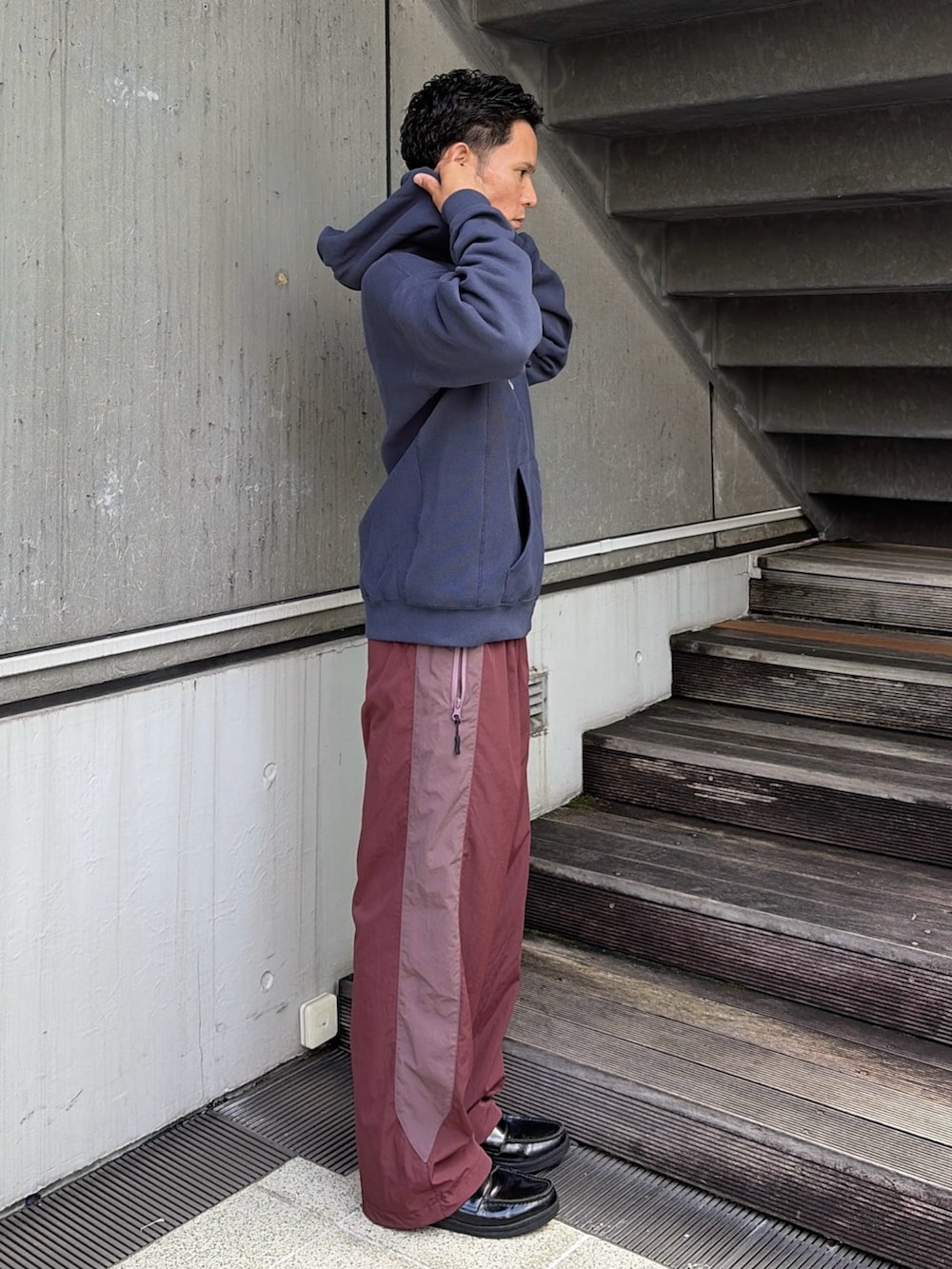 グレー系のパーカー、レッド系のその他パンツを着用したメンズの秋コーディネートの3枚目の写真