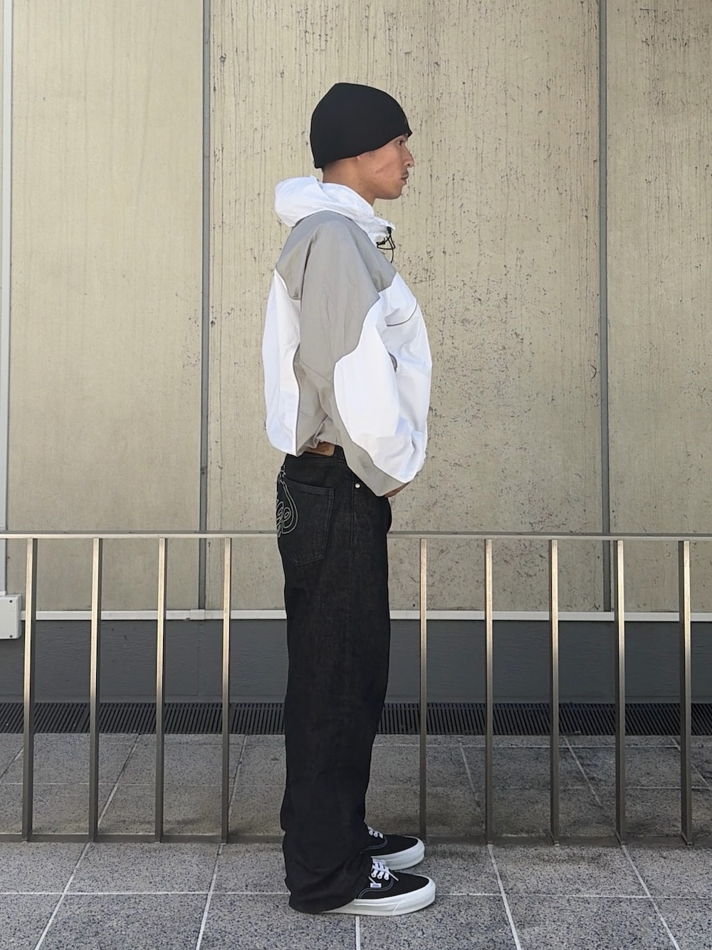 ブルー系のナイロンジャケット、ブラック系のデニムパンツ、ピンク系のニットキャップ/ビーニーを着用したメンズの春コーディネートの4枚目の写真