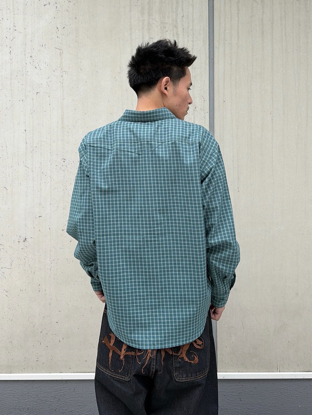 グリーン系のシャツ/ブラウス、ブラック系のデニムパンツを着用したメンズの春コーディネートの4枚目の写真