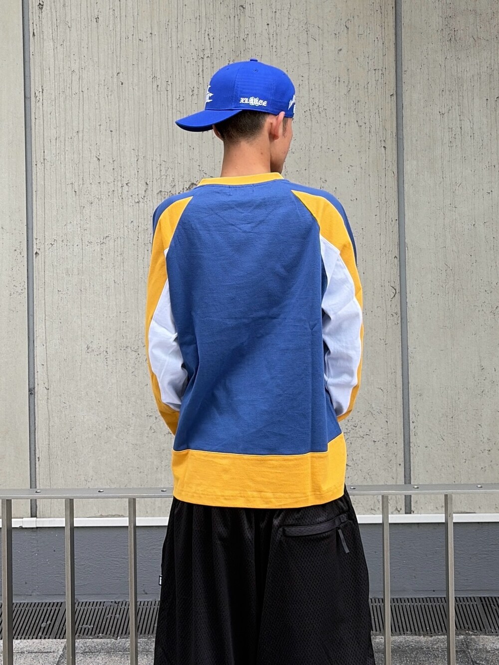 ブラック系のその他パンツ、ブルー系のTシャツ/カットソー、ブルー系のキャップを着用したメンズの夏コーディネートの7枚目の写真