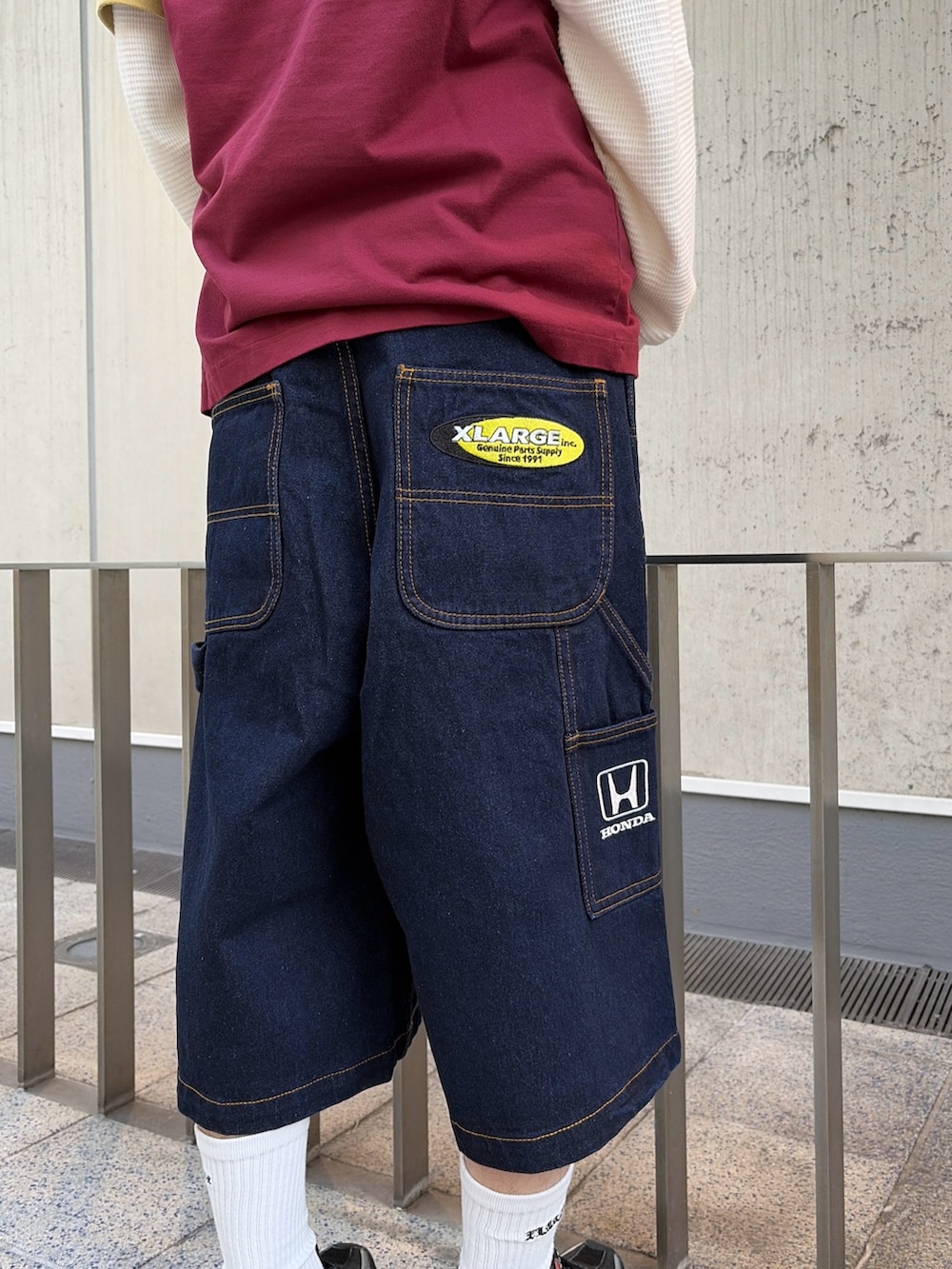 レッド系のTシャツ/カットソー、ブルー系のデニムパンツ、ホワイト系のTシャツ/カットソーを着用したメンズの春コーディネートの7枚目の写真