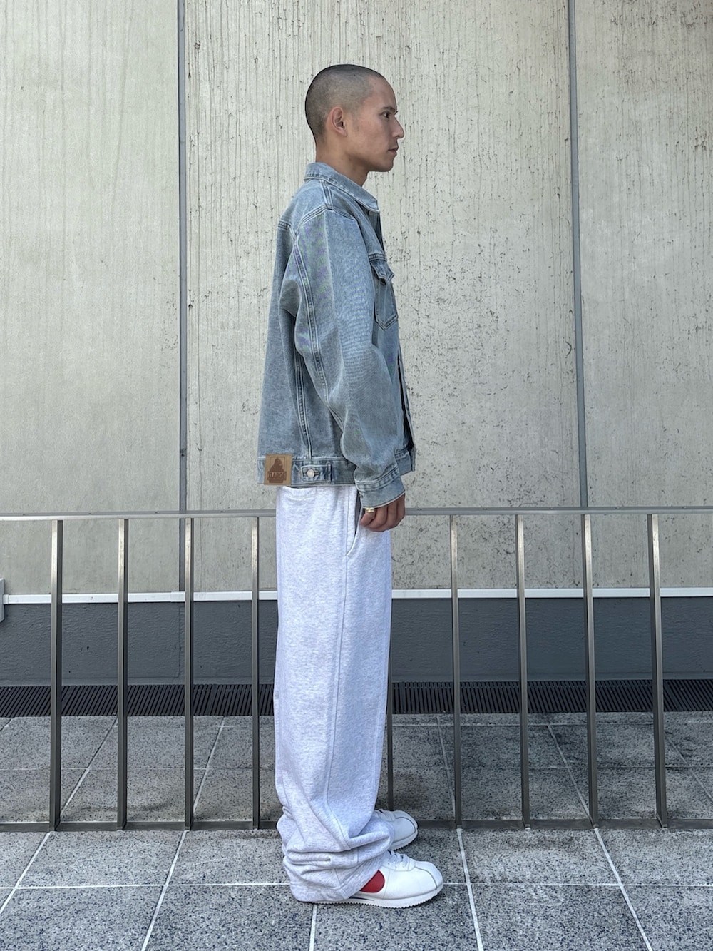 ブラック系のデニムジャケット、グレー系のスウェットパンツを着用したメンズの秋コーディネートの5枚目の写真