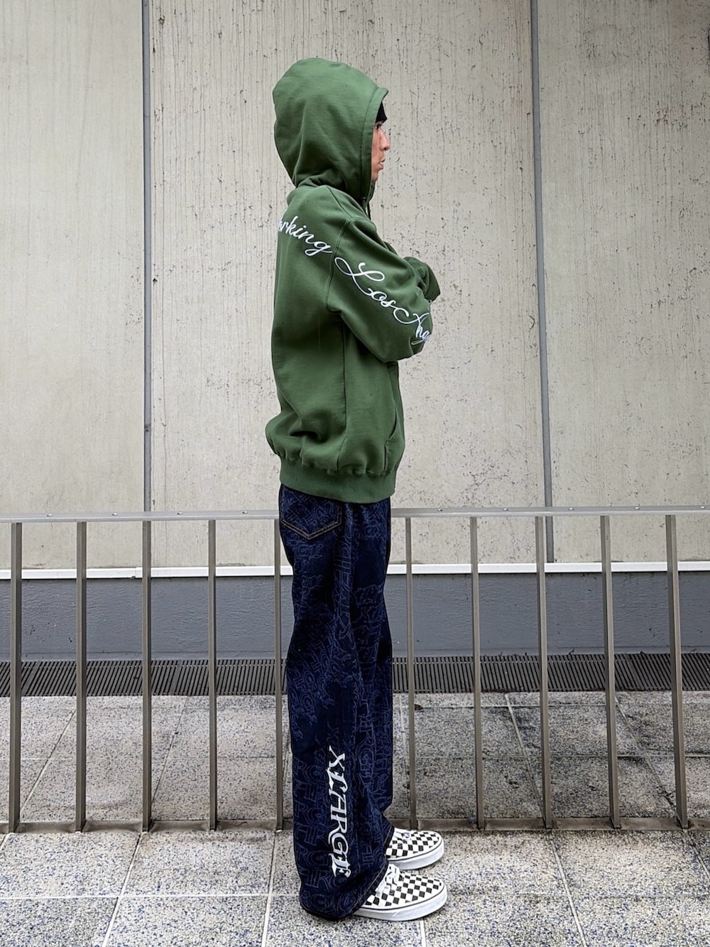 グリーン系のパーカー、ブルー系のデニムパンツ、レッド系のニットキャップ/ビーニーを着用したメンズの秋コーディネートの4枚目の写真