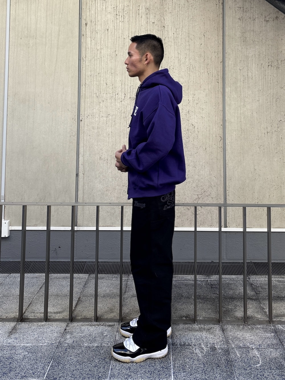 パープル系のパーカー、ブラック系のその他パンツを着用したメンズの冬コーディネートの2枚目の写真