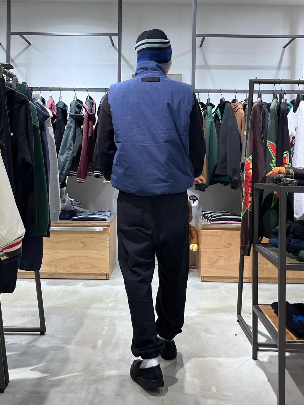 グレー系のスウェットパンツ、ブルー系のベスト、ブラック系のニット/セーターを着用したメンズの秋コーディネートの5枚目の写真