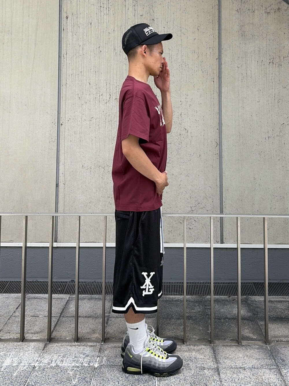 レッド系のTシャツ/カットソー、ブラック系のその他パンツ、ブラック系のキャップを着用したメンズの夏コーディネートの3枚目の写真