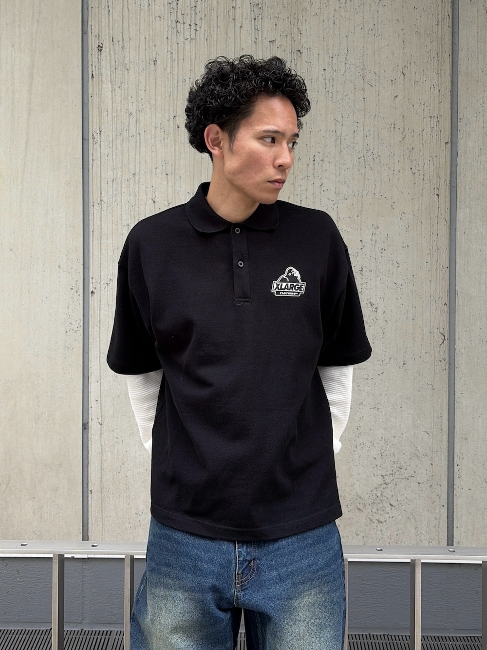 ホワイト系のTシャツ/カットソー、ブラック系のポロシャツ、ブルー系のデニムパンツを着用したメンズの春コーディネートの5枚目の写真