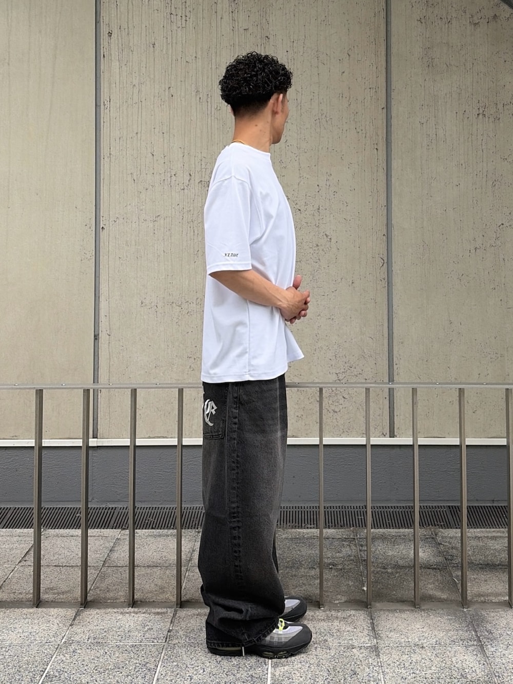ホワイト系のTシャツ/カットソー、ブラック系のデニムパンツを着用したメンズの夏コーディネートの4枚目の写真