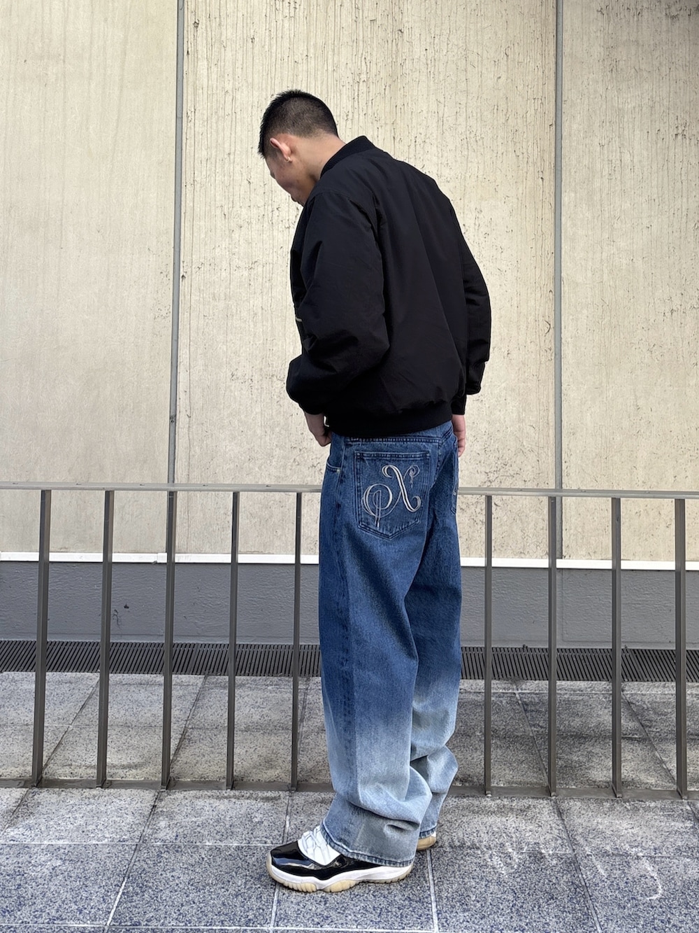 ブラック系のブルゾン、ブルー系のデニムパンツを着用したメンズの冬コーディネートの2枚目の写真