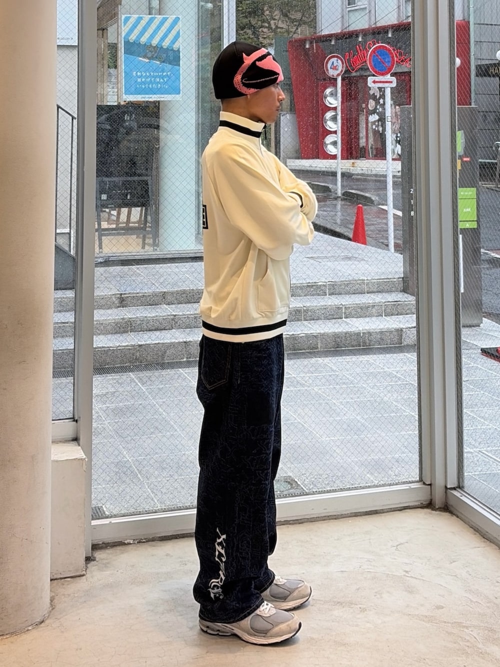 ホワイト系のブルゾン、ブルー系のデニムパンツ、ブルー系のキャップを着用したメンズの秋コーディネートの3枚目の写真