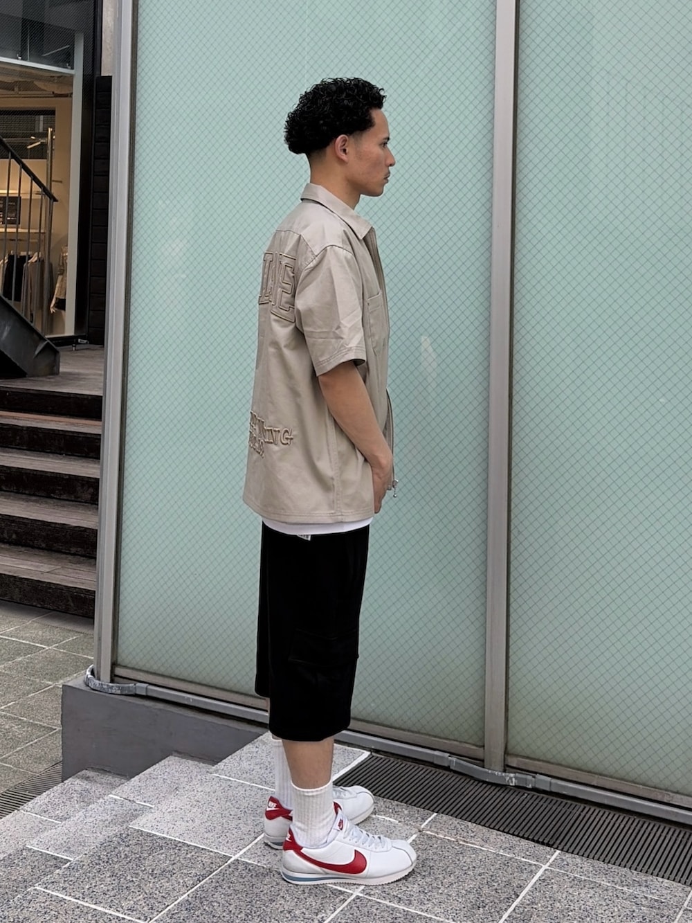 ブラック系のカーゴパンツ、グリーン系のシャツ/ブラウス、ホワイト系のTシャツ/カットソーを着用したメンズの春コーディネートの3枚目の写真