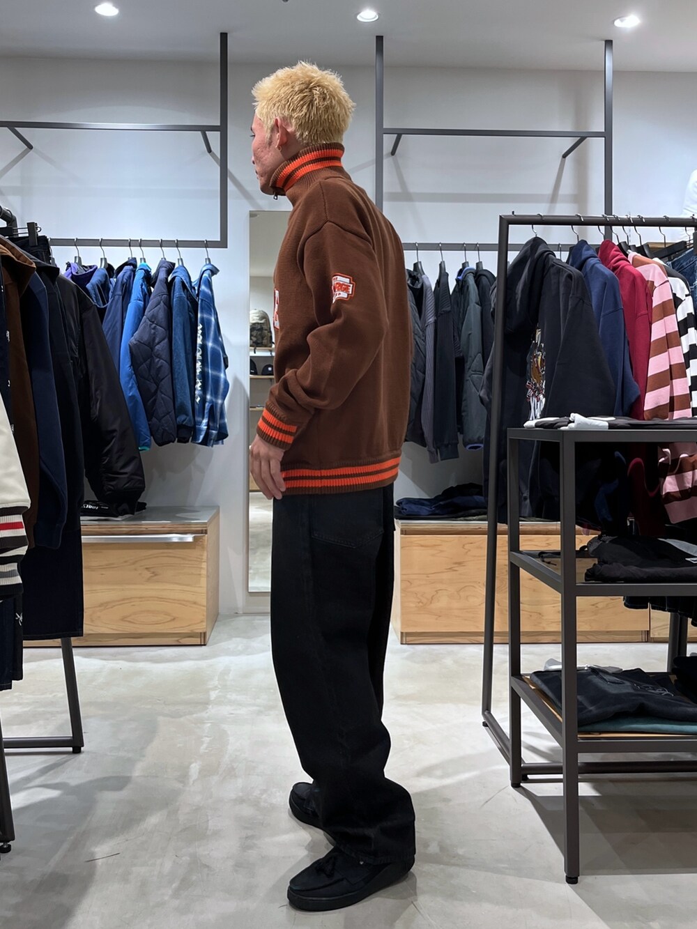 ブラック系のデニムパンツ、ブラウン系のニット/セーターを着用したメンズの秋コーディネートの2枚目の写真