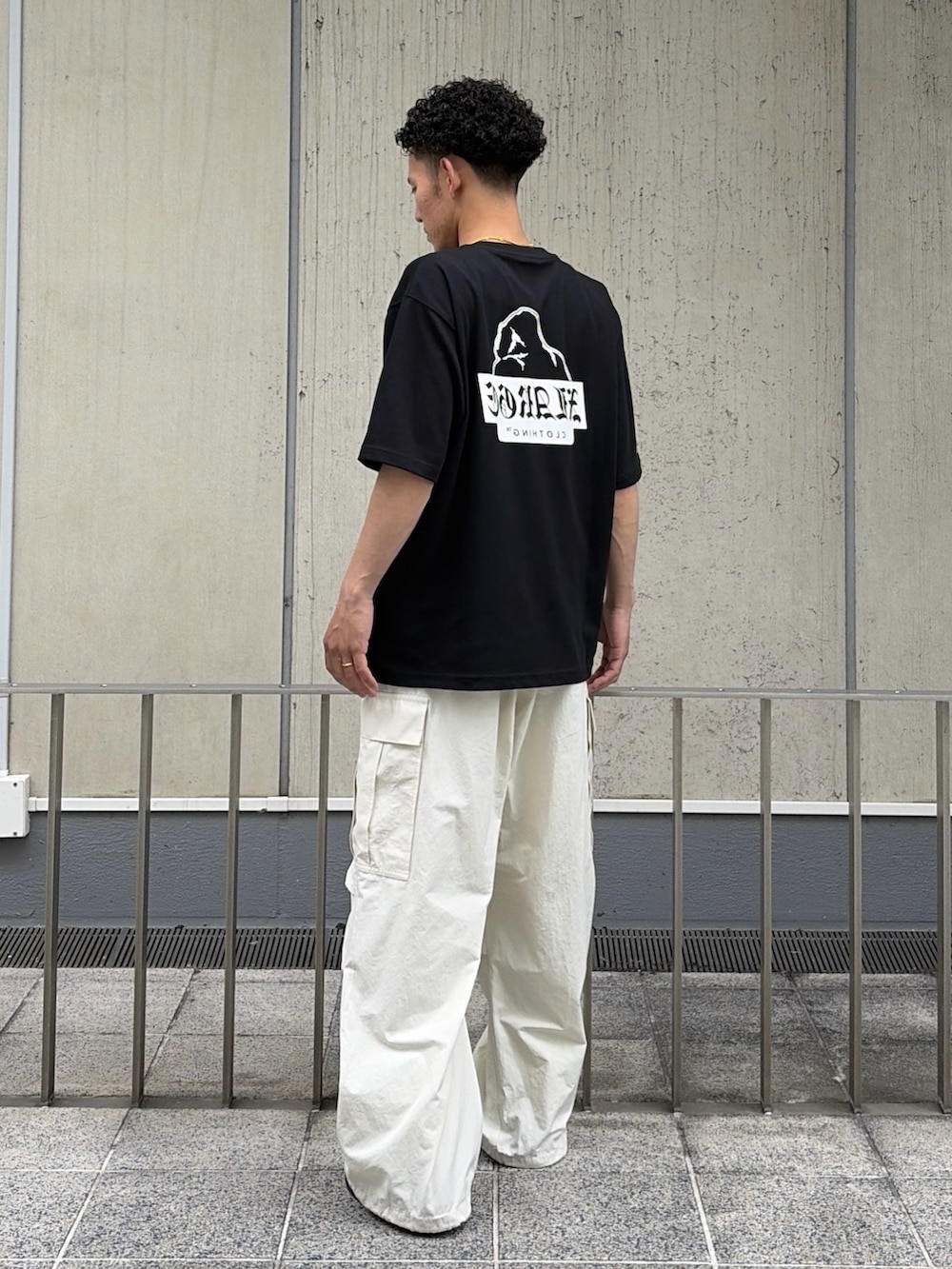 ブラック系のTシャツ/カットソー、ホワイト系のカーゴパンツを着用したメンズの夏コーディネートの4枚目の写真