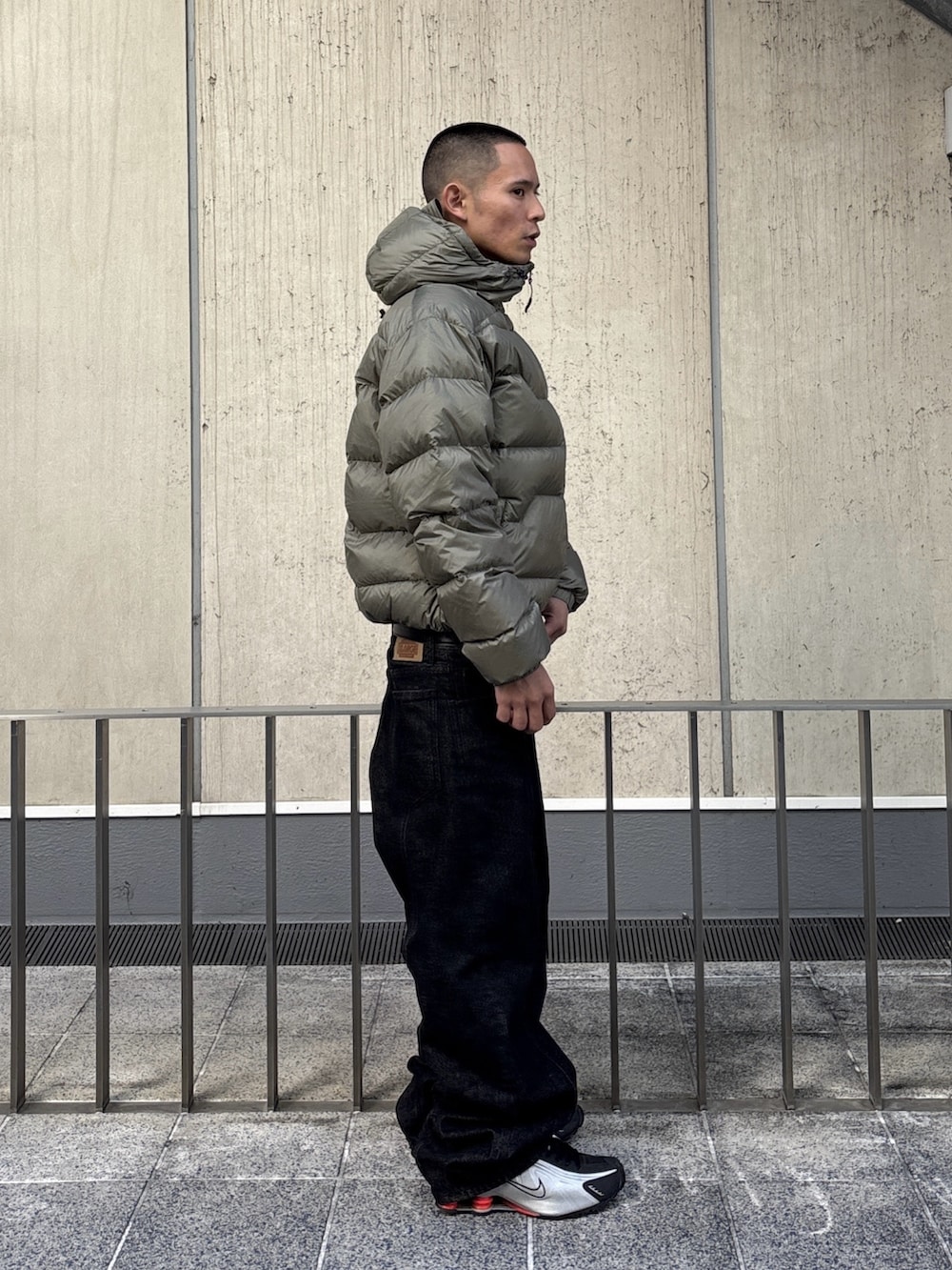 グリーン系のダウンジャケット/コート、ブラック系のデニムパンツを着用したメンズの秋コーディネートの3枚目の写真