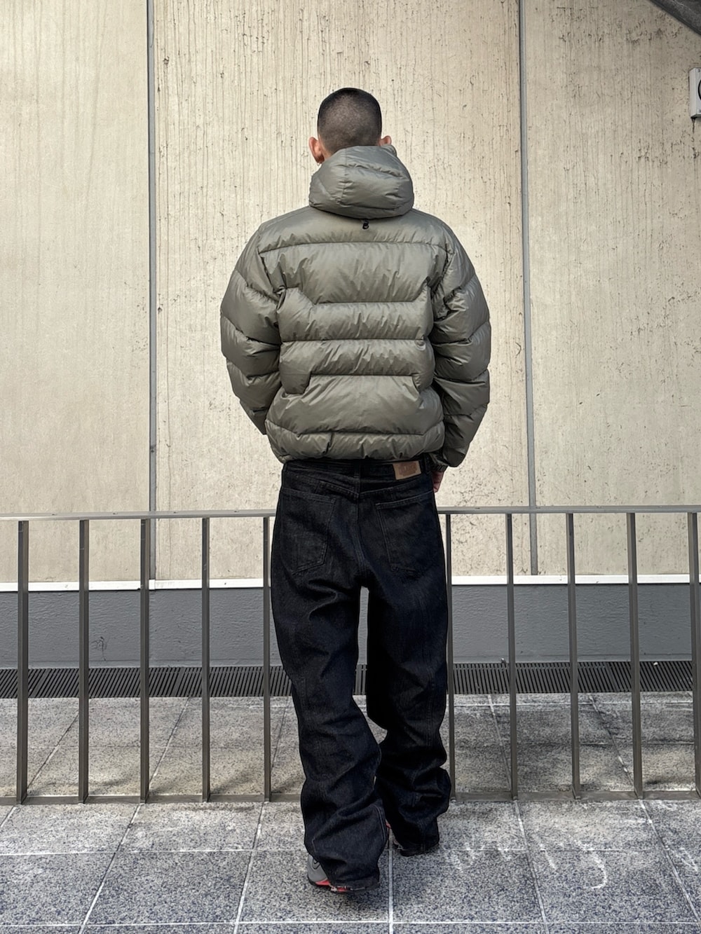 グリーン系のダウンジャケット/コート、ブラック系のデニムパンツを着用したメンズの秋コーディネートの4枚目の写真