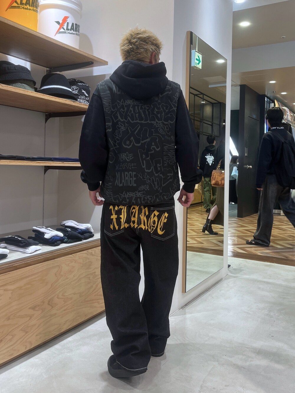 ブラック系のベスト、ブラック系のパーカー、ブラック系のデニムパンツを着用したメンズの秋コーディネートの4枚目の写真