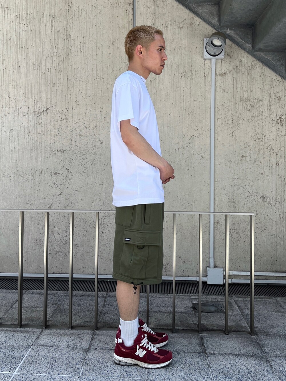 ホワイト系のTシャツ/カットソー、グリーン系のカーゴパンツを着用したメンズの春コーディネートの3枚目の写真