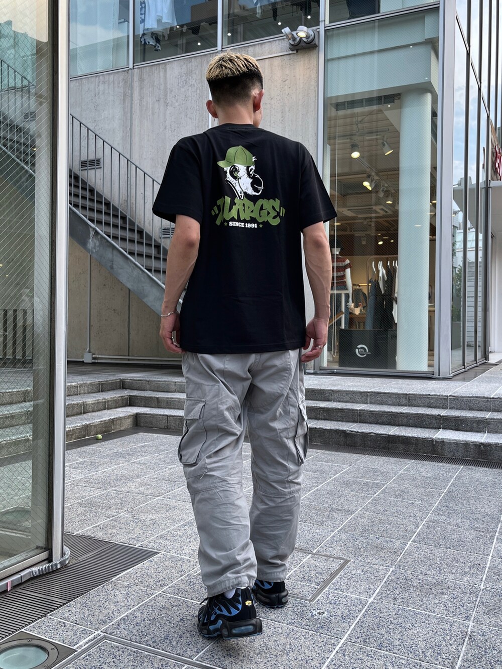 ブラック系のTシャツ/カットソー、グレー系のカーゴパンツを着用したメンズの夏コーディネートの4枚目の写真