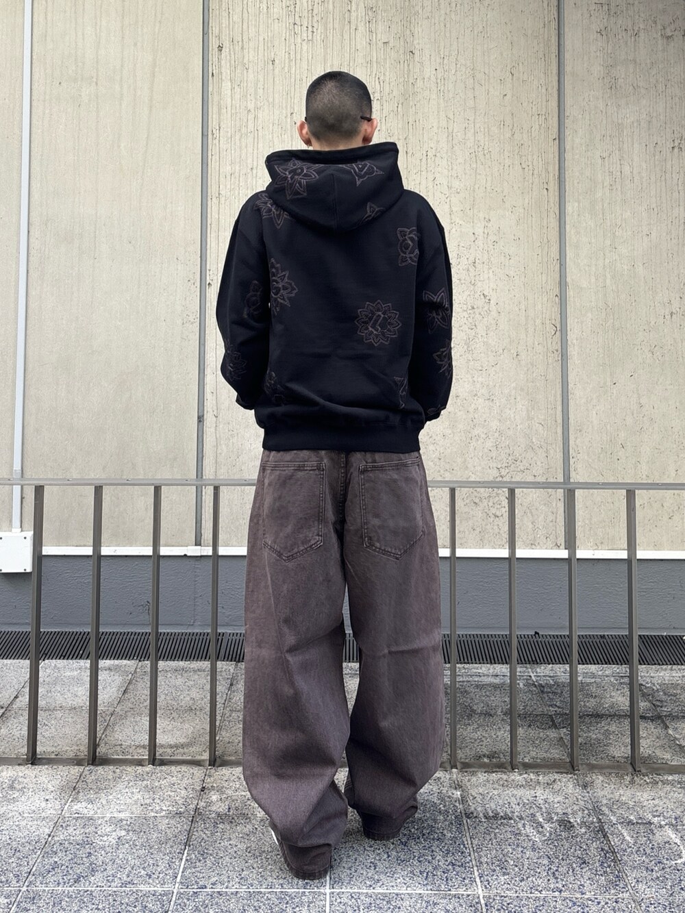 ブラック系のパーカー、ブラウン系のデニムパンツを着用したメンズの冬コーディネートの3枚目の写真